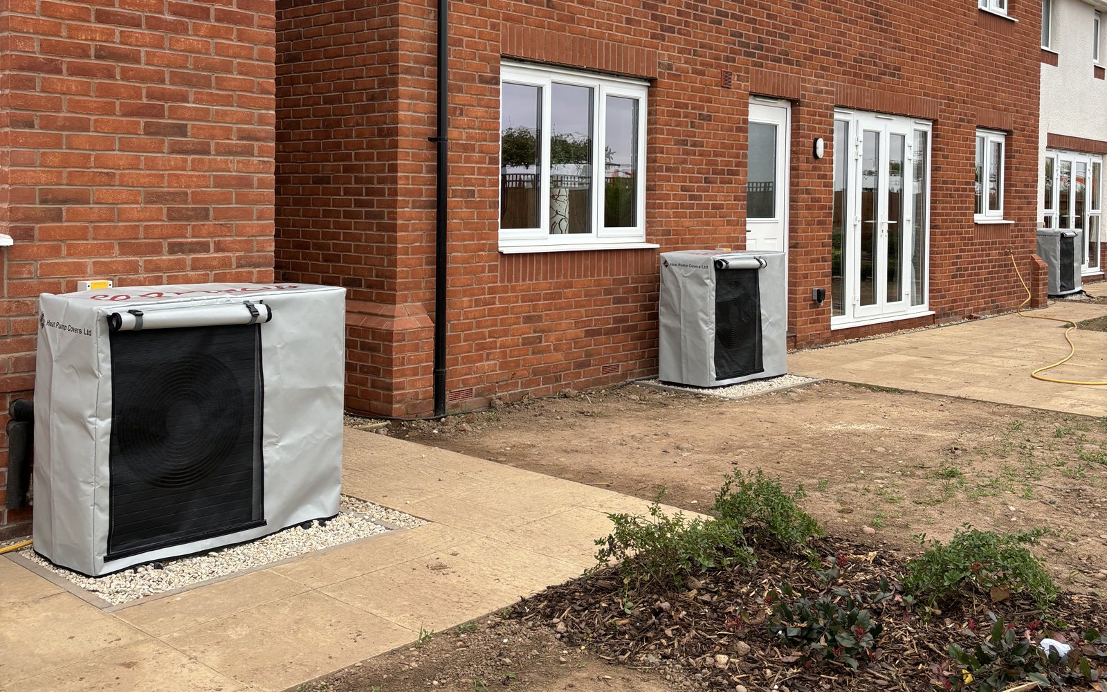 Heat pump covers fitted behind new homes while landscaping is finished